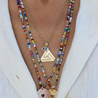 Small Abracadabra Triangle Series 1 with Love is My Religion Pendants layered to create a meaningful and unique necklace stack. 
