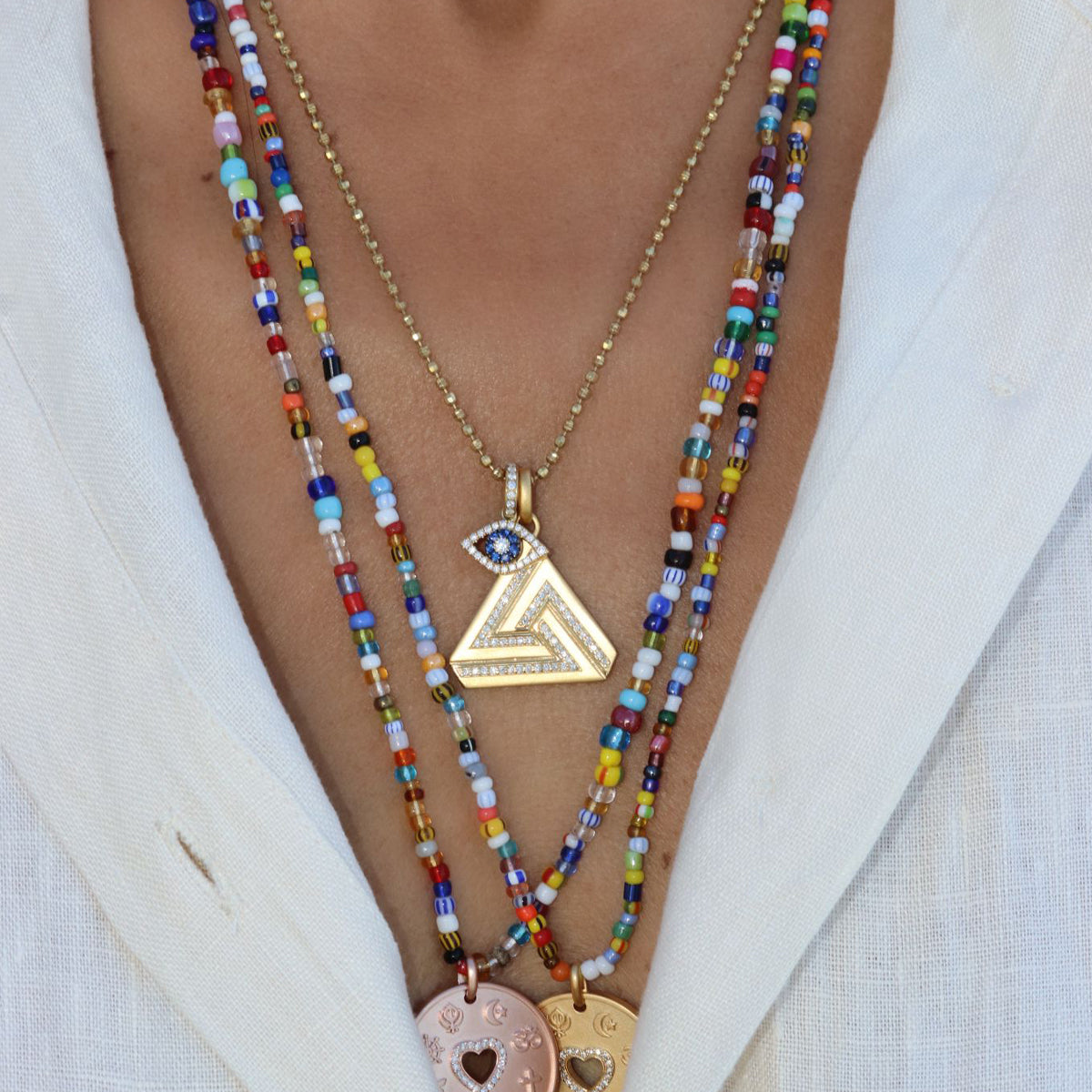 Small Abracadabra Triangle Series 1 with Love is My Religion Pendants layered to create a meaningful and unique necklace stack. 